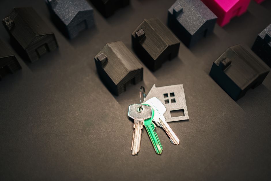 Miniature house models and keys symbolize real estate investment and housing market.